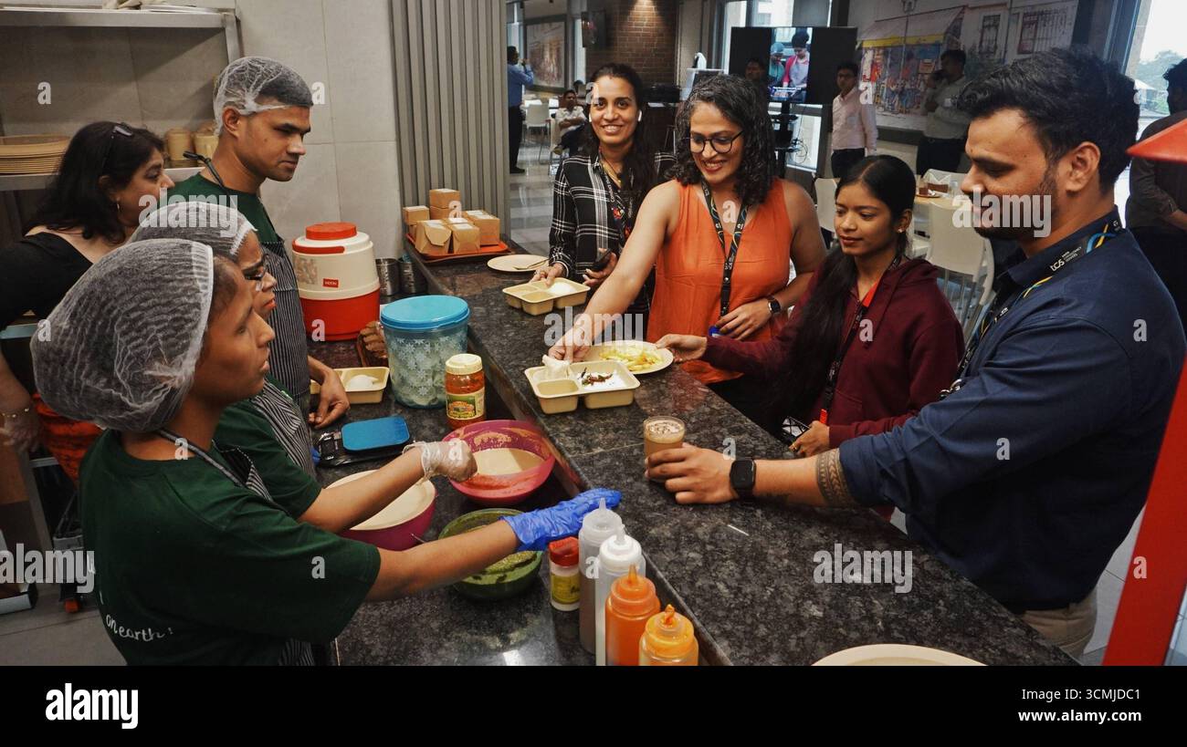 MUMBAI, INDIA - 16 SETTEMBRE: Tre ciechi hanno visto servire cibo nella cucina del caffè, dopo il lancio del Blind Bake Café al TCS Olympus Campus, Ghodbunder Road, Thane, il 16 settembre 2025 a Mumbai, India. Thane Tata Consultancy Services TCS ha introdotto un'iniziativa unica e stimolante presso il suo Olympus Campus in Ghodbunder Road a Thane. Per la prima volta nel settore aziendale, è stato inaugurato un caffè gestito interamente da persone ipovedenti, il Blind Bake Café. Il caffè è stato creato attraverso una collaborazione congiunta tra TCS e l'Associazione Nazionale per la B. Foto Stock