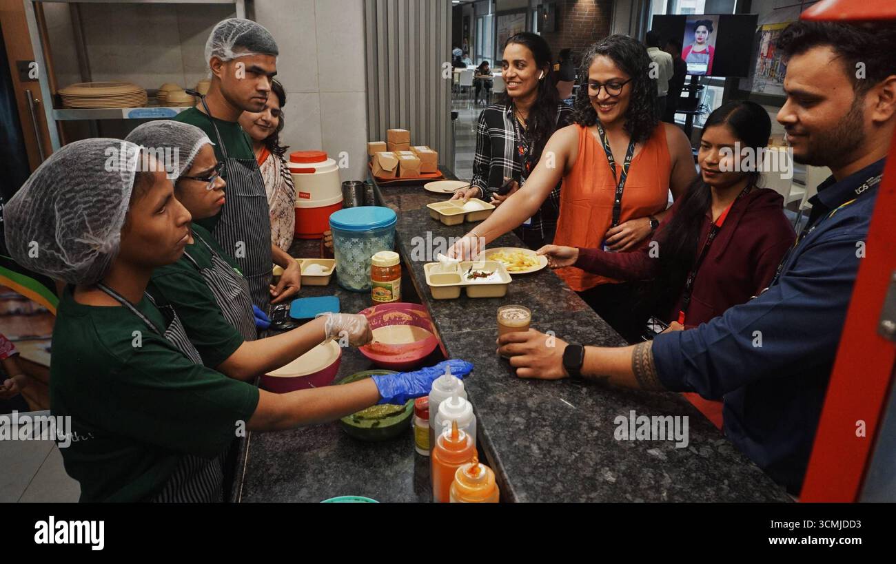 MUMBAI, INDIA - 16 SETTEMBRE: Tre ciechi hanno visto servire cibo nella cucina del caffè, dopo il lancio del Blind Bake Café al TCS Olympus Campus, Ghodbunder Road, Thane, il 16 settembre 2025 a Mumbai, India. Thane Tata Consultancy Services TCS ha introdotto un'iniziativa unica e stimolante presso il suo Olympus Campus in Ghodbunder Road a Thane. Per la prima volta nel settore aziendale, è stato inaugurato un caffè gestito interamente da persone ipovedenti, il Blind Bake Café. Il caffè è stato creato attraverso una collaborazione congiunta tra TCS e l'Associazione Nazionale per la B. Foto Stock