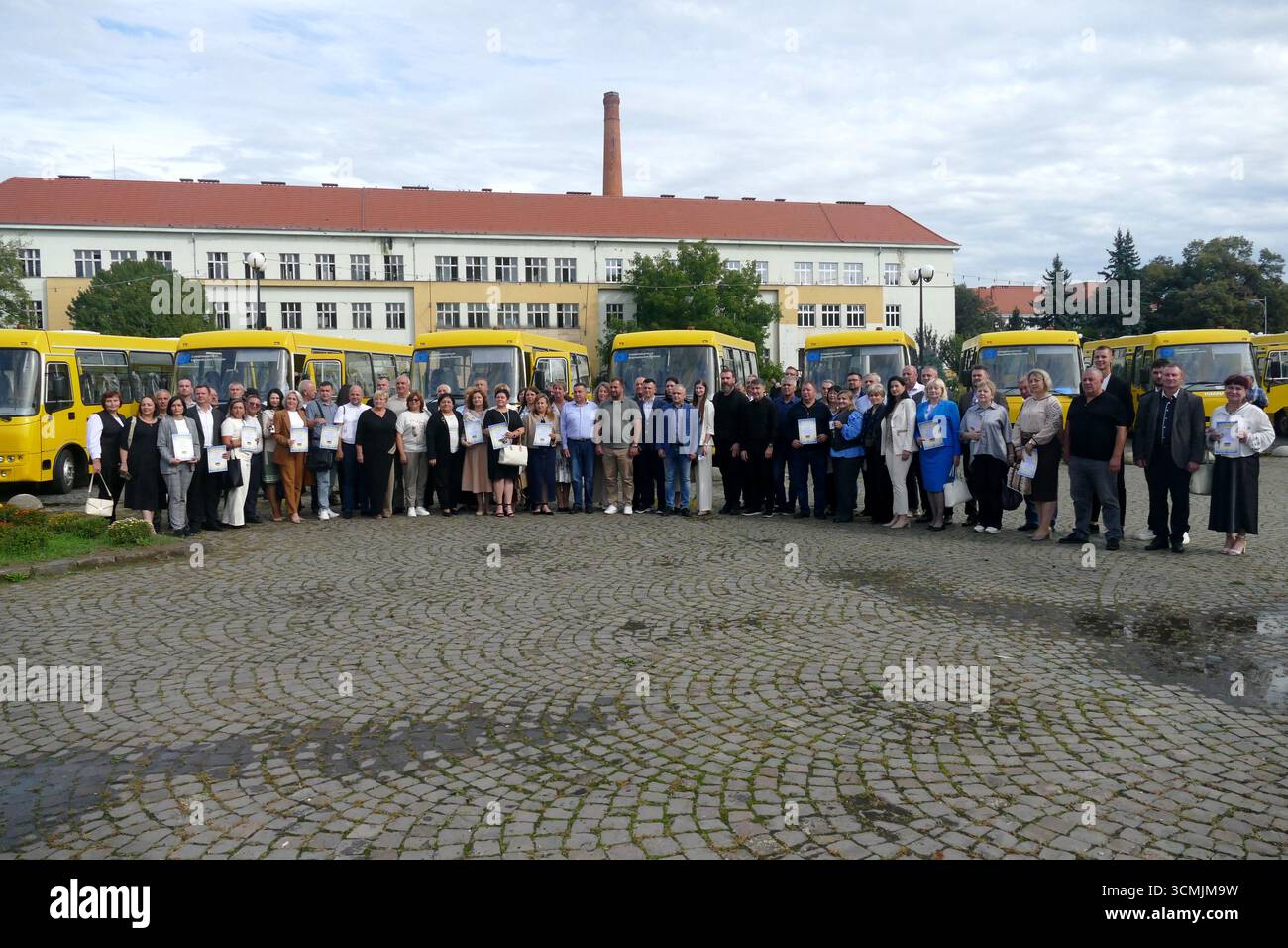 Funzionari e leader della comunità partecipano alla presentazione di 19 nuovi scuolabus acquistati nell'ambito dell'iniziativa "scuolabus per l'Ucraina" alle scuole e alle comunità territoriali di Zakarpattia, Uzhhorod, Ucraina, 16 settembre 2025 (foto di Yulii Zozulia/Ukrinform) Foto Stock