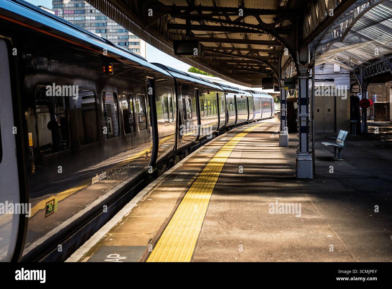 Moderno treno passeggeri con porte chiuse sulla piattaforma vuota della stazione ferroviaria Foto Stock