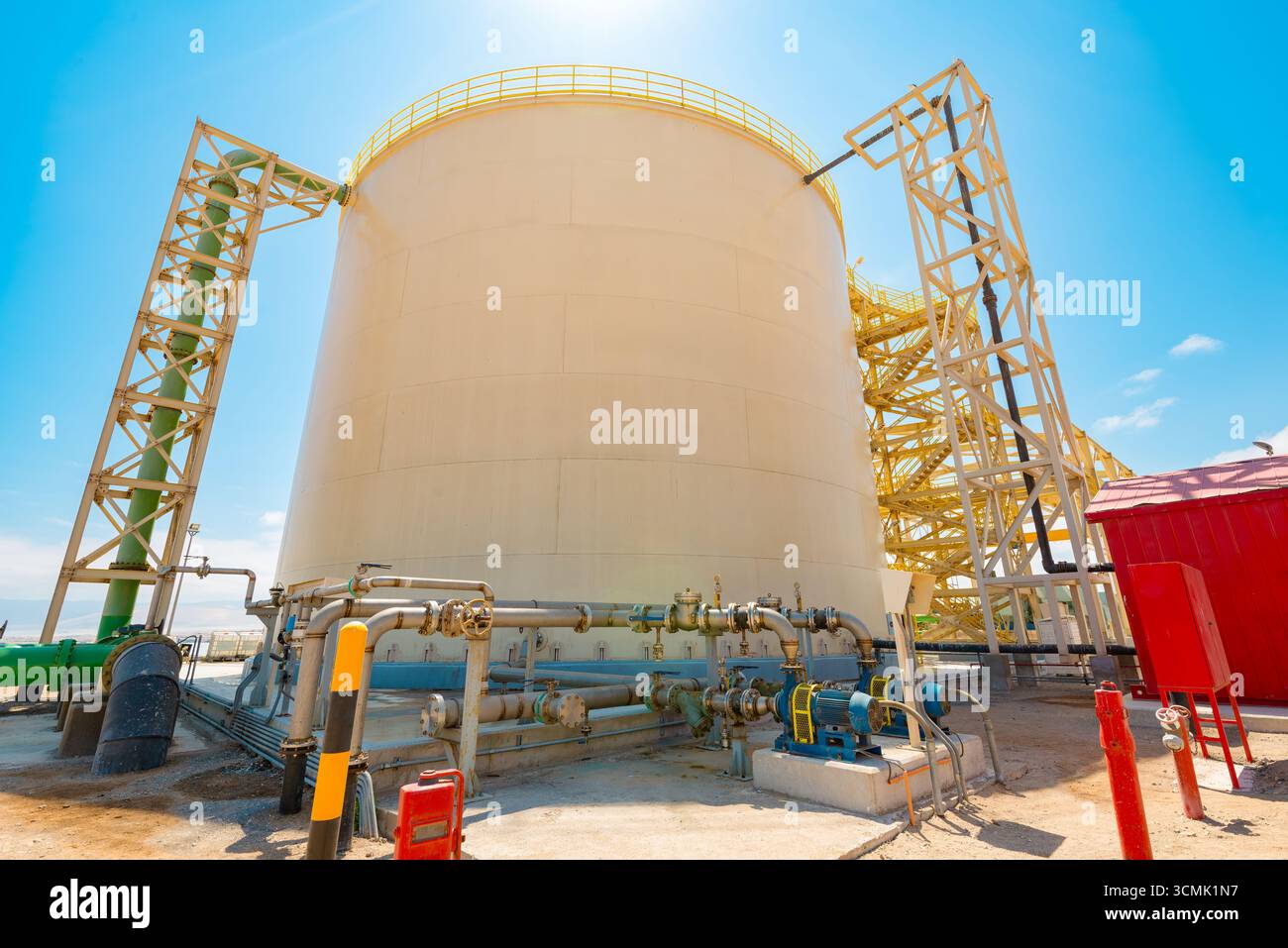 Grande serbatoio dell'acqua utilizzato per immagazzinare acqua purificata in un impianto di desalinizzazione a osmosi inversa, con tubi industriali alla base. Foto Stock