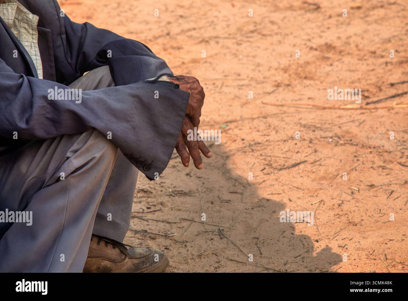 mani di vecchio uomo africano del villaggio , adagiate sul terreno di siccità di sabbia del cortile, sud africa, Foto Stock