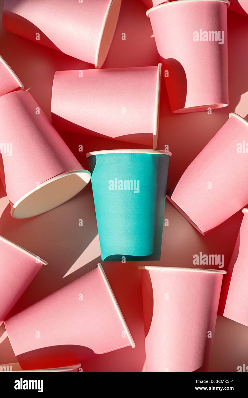 Tazza di carta color azzurro che spicca tra le tante tazze rosa. Concetto di unicità e individualità. Diverso dall'idea della folla. Foto Stock Tazza di carta color azzurro che spicca tra le tante tazze rosa. Concetto di unicità e individualità. Diverso dall'idea della folla. Foto Stock