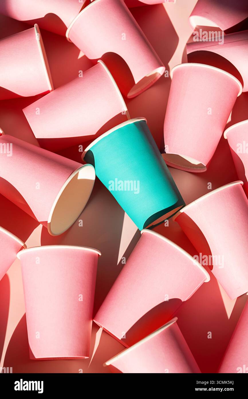 Tazza di tè che spicca tra le tante tazze di carta rosa. Individualità, unicità e concetto di leadership. Gruppi diversi di oggetti. Foto Stock Tazza di tè che spicca tra le tante tazze di carta rosa. Individualità, unicità e concetto di leadership. Gruppi diversi di oggetti. Foto Stock