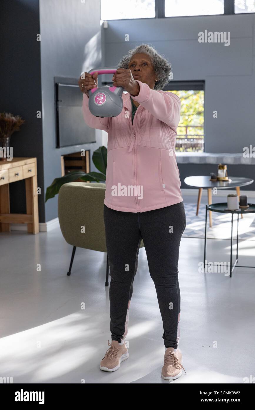 Campana grigia appoggiata su pavimento pallido nel soggiorno con tavolino in legno e pianta verde Foto Stock