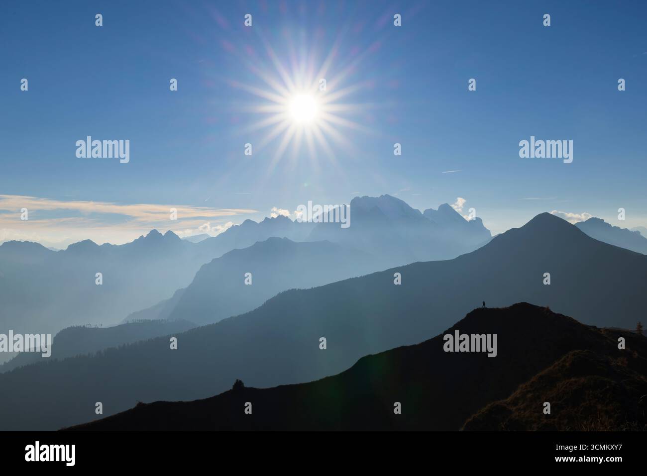 Splendida vista del sole che splende sulla catena montuosa delle Dolomiti italiane, creando un paesaggio mozzafiato Foto Stock