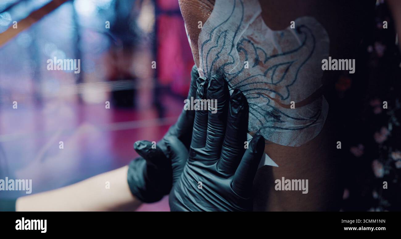 Tatuatore, stencil e mani con la persona in negozio per il design della body art, lo studio al neon o la cultura. Consentire l'estetica dell'inchiostro, il cliente e la grafica con Foto Stock