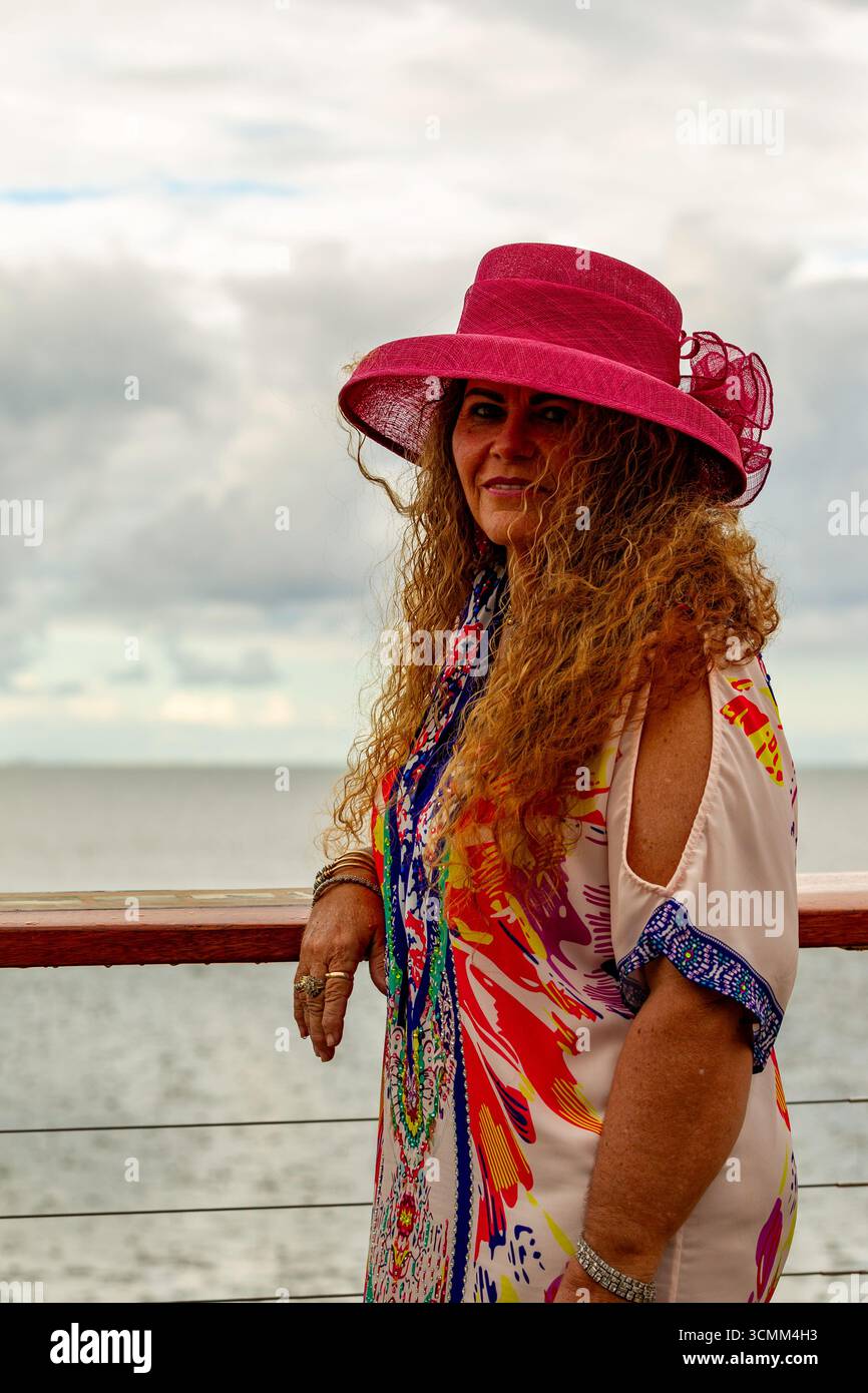 cappello per capelli sorridente signora lookout colore abito completo lunghi capelli marroni ricci 50 più modelli modelli maturi modella australia australiana Foto Stock