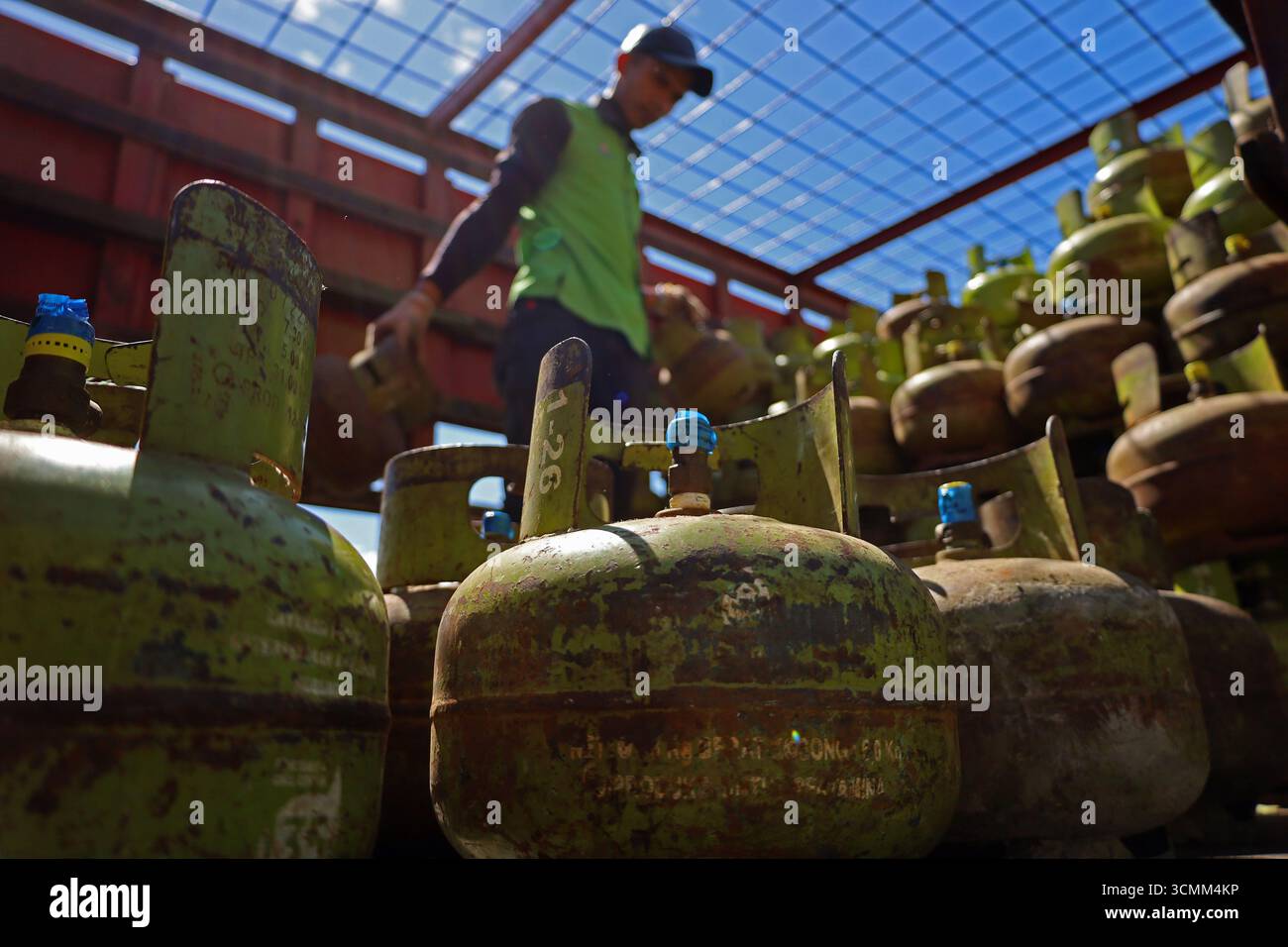 Banda Aceh, Aceh, Indonesia. 17 settembre 2025. Mercoledì 17 settembre 2025, i lavoratori scaricano centinaia di bombole di gas sovvenzionate da 3 kg dall'interno di un camion di trasporto presso il mercato agricolo di banda Aceh City, provincia di Aceh, Indonesia. Pertamina Patra Niaga della regione di Sumbagut distribuì un ulteriore tubo GPL da 3 kg con un sussidio di 147.280 tubi o del 105% ad Aceh al fine di rafforzare l'approvvigionamento e non interferire con la distribuzione. Nel 2025 il governo indonesiano ha stanziato circa 87,6000 miliardi di Rp394 miliardi per sovvenzioni al GPL di 3 kg, con un bilancio totale di sovvenzioni all'energia e compensazioni di 3,6000 Rp394 trilioni Foto Stock