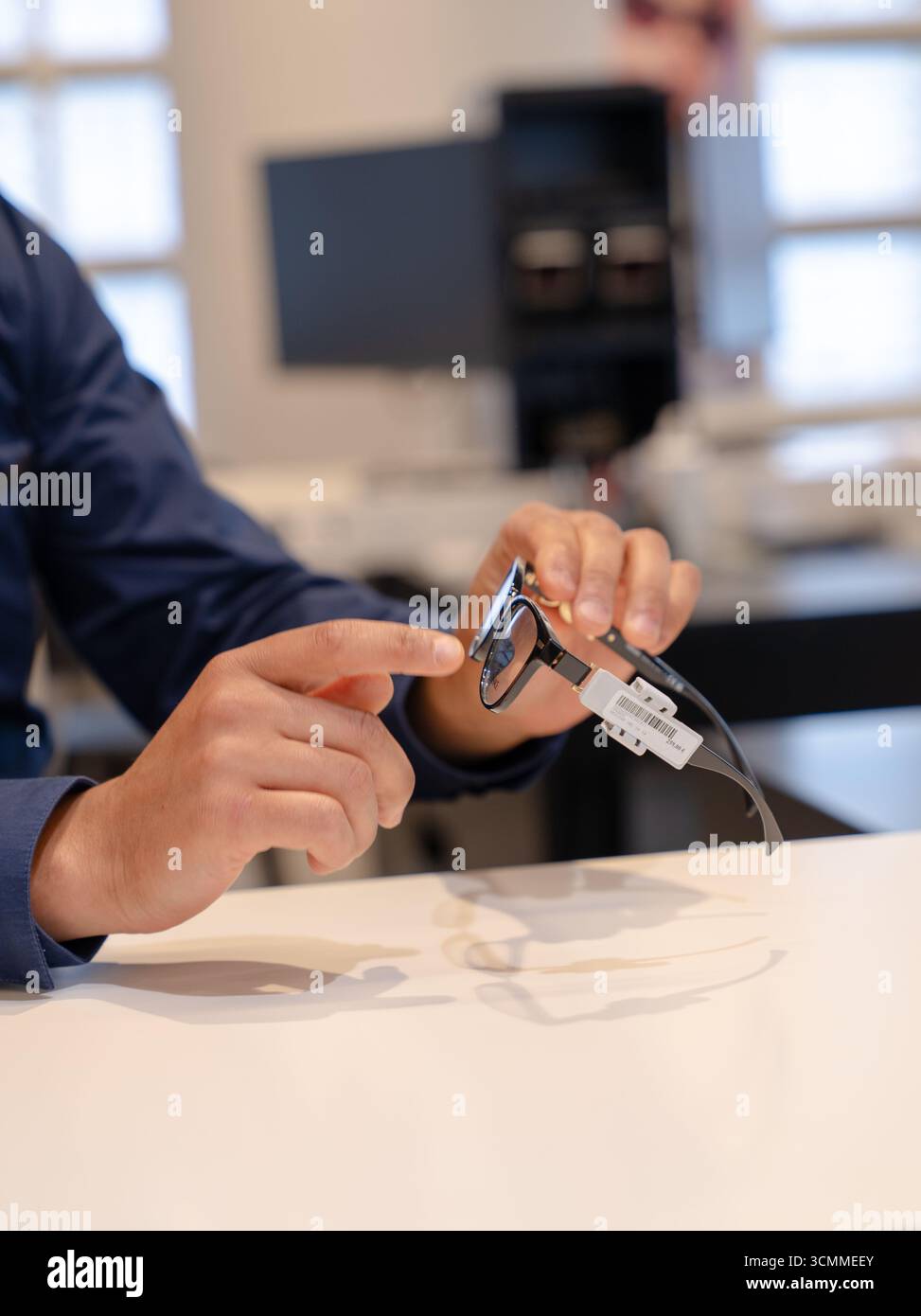 Negozio ottico: Ottico che mostra lenti correttive Foto Stock