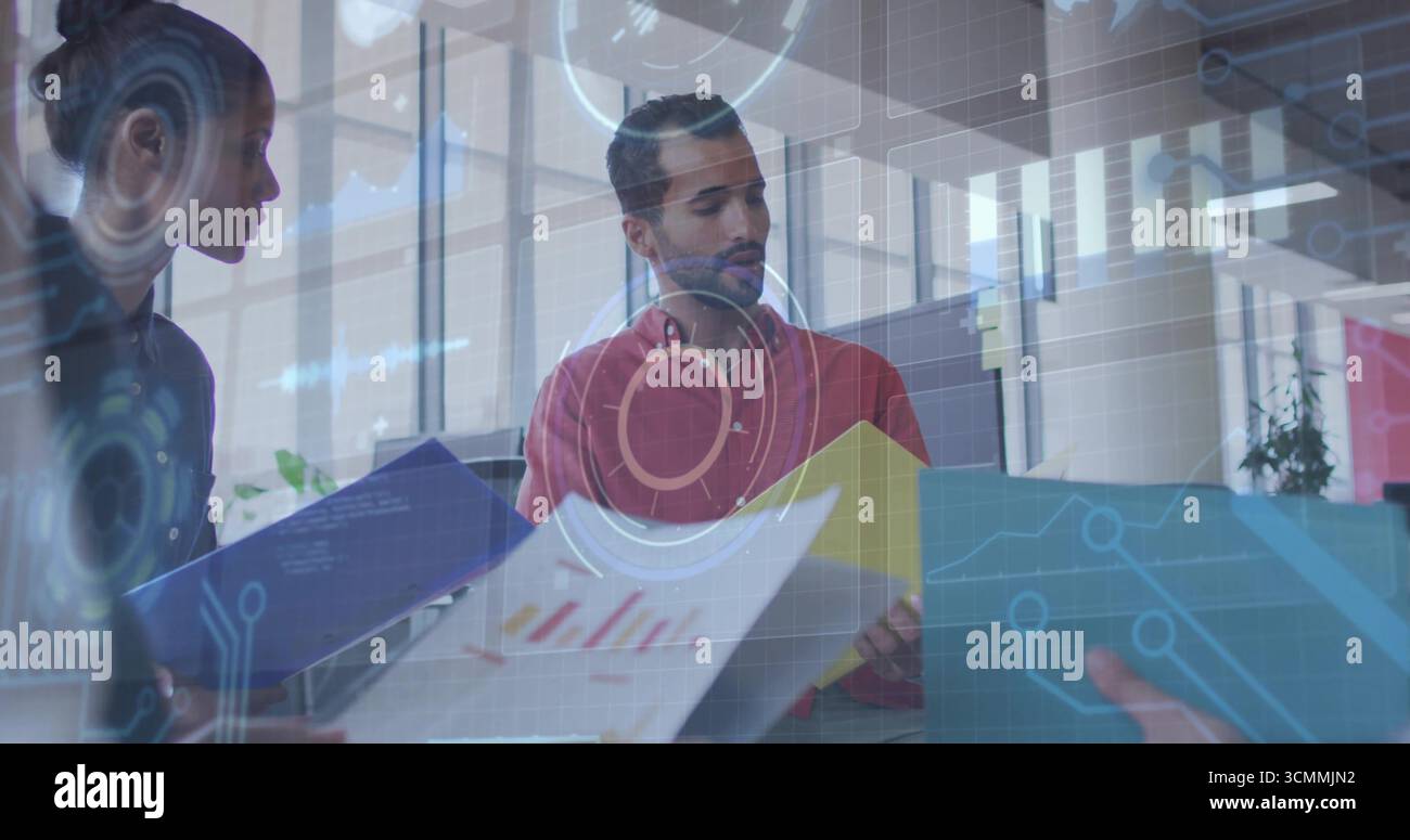 Analisi di un uomo in camicia rossa che interpreta le carte stampate alla scrivania dell'ufficio, con sovrapposizioni di dati Foto Stock