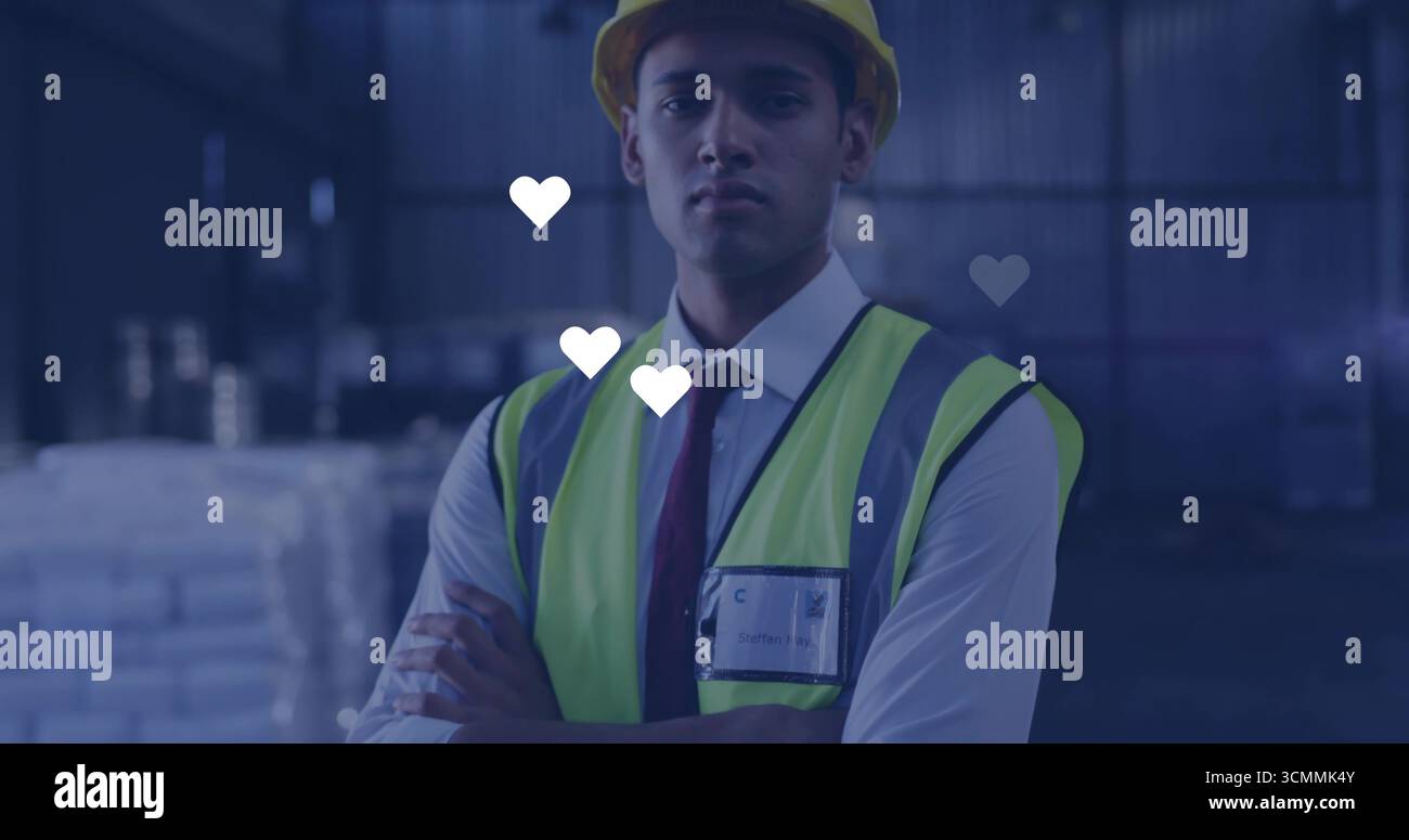 Supervisore del sito che indossa giubbotto di sicurezza, casco, badge di identificazione all'interno del magazzino, pallet impilati Foto Stock