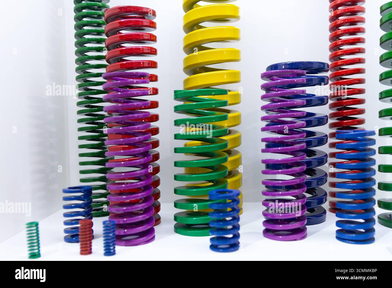 Varie sorgenti di metallo colorato sullo stand espositivo. Industria Foto Stock