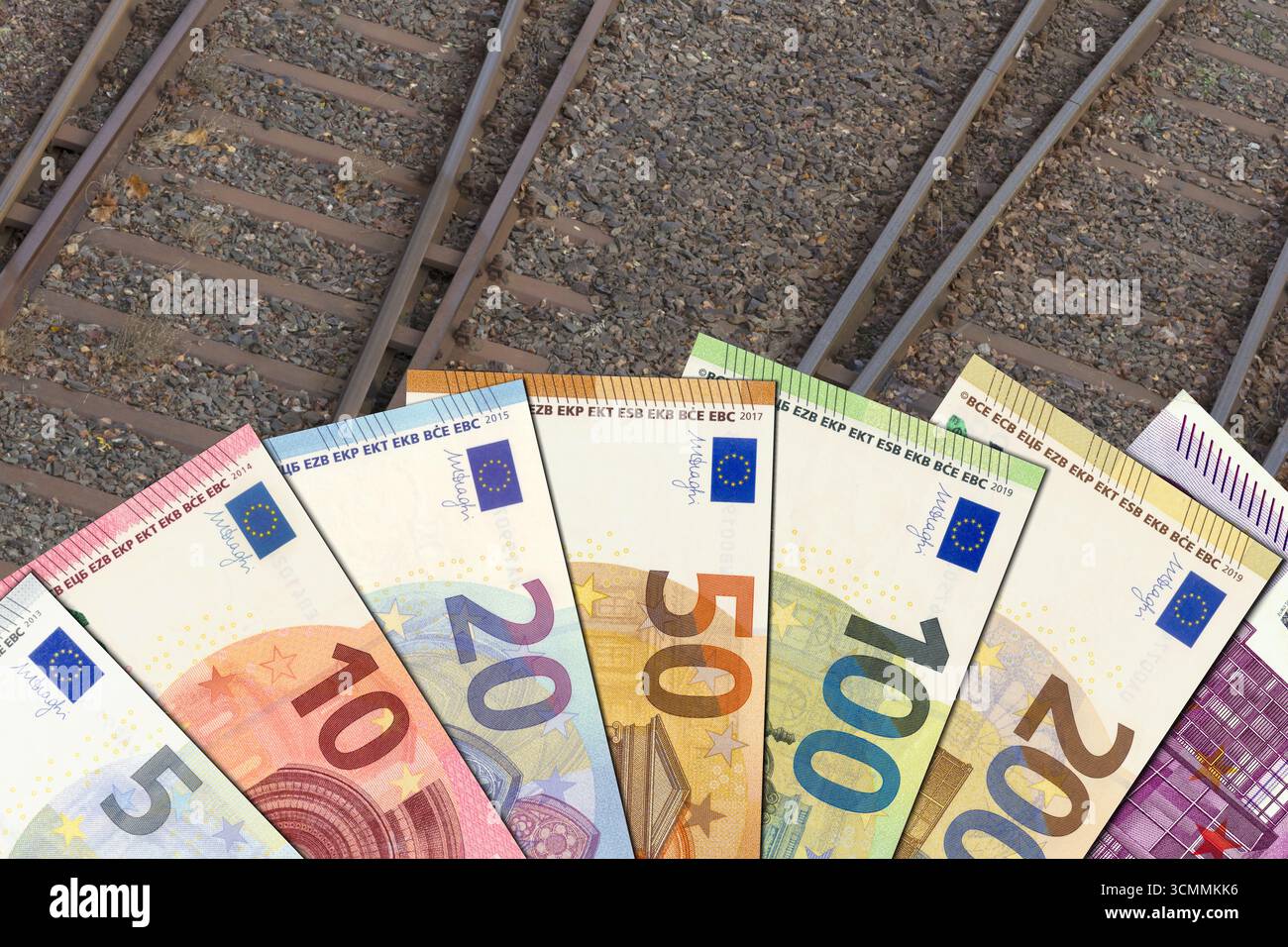 Banconote in euro sulle rotaie – denaro per le ferrovie Foto Stock