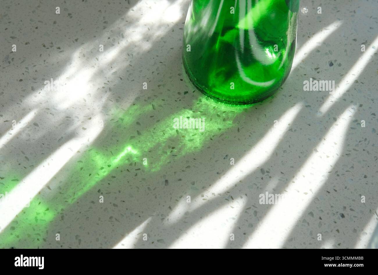 ombra di una bottiglia di vetro verde sul piano di lavoro della cucina Foto Stock