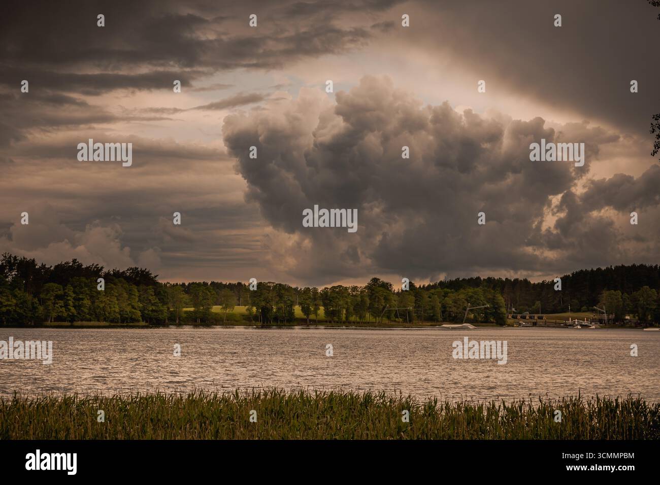 Cielo spettacolare con nuvole buie e tempestose sotto lo sfondo del lago Foto Stock