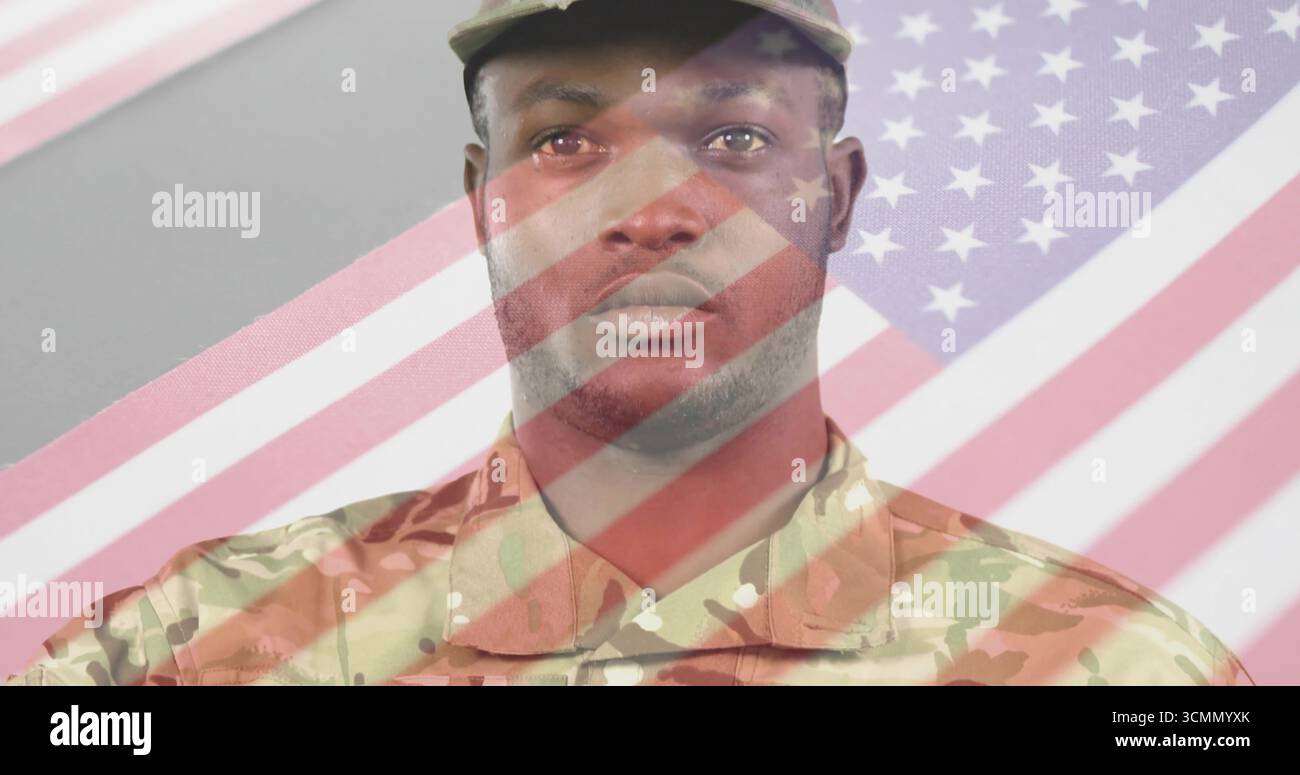 Soldato maschile in piedi con uniforme da combattimento mimetica e berretto in studio grigio, con copertura bandiera Foto Stock