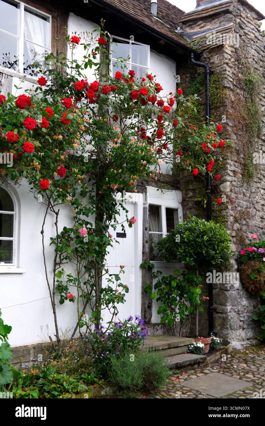 Pittoresca facciata di Cottage adornata con Red Roses: Much Wenlock Shropshire, West Midlands, Inghilterra Regno Unito Foto Stock