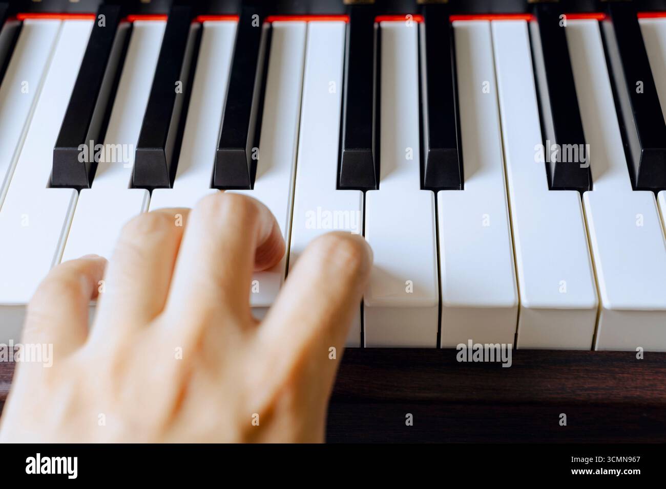 Le mani di un uomo si esercitano diligentemente per migliorare le sue capacità di pianoforte. Primo piano. Foto concettuale. Foto Stock