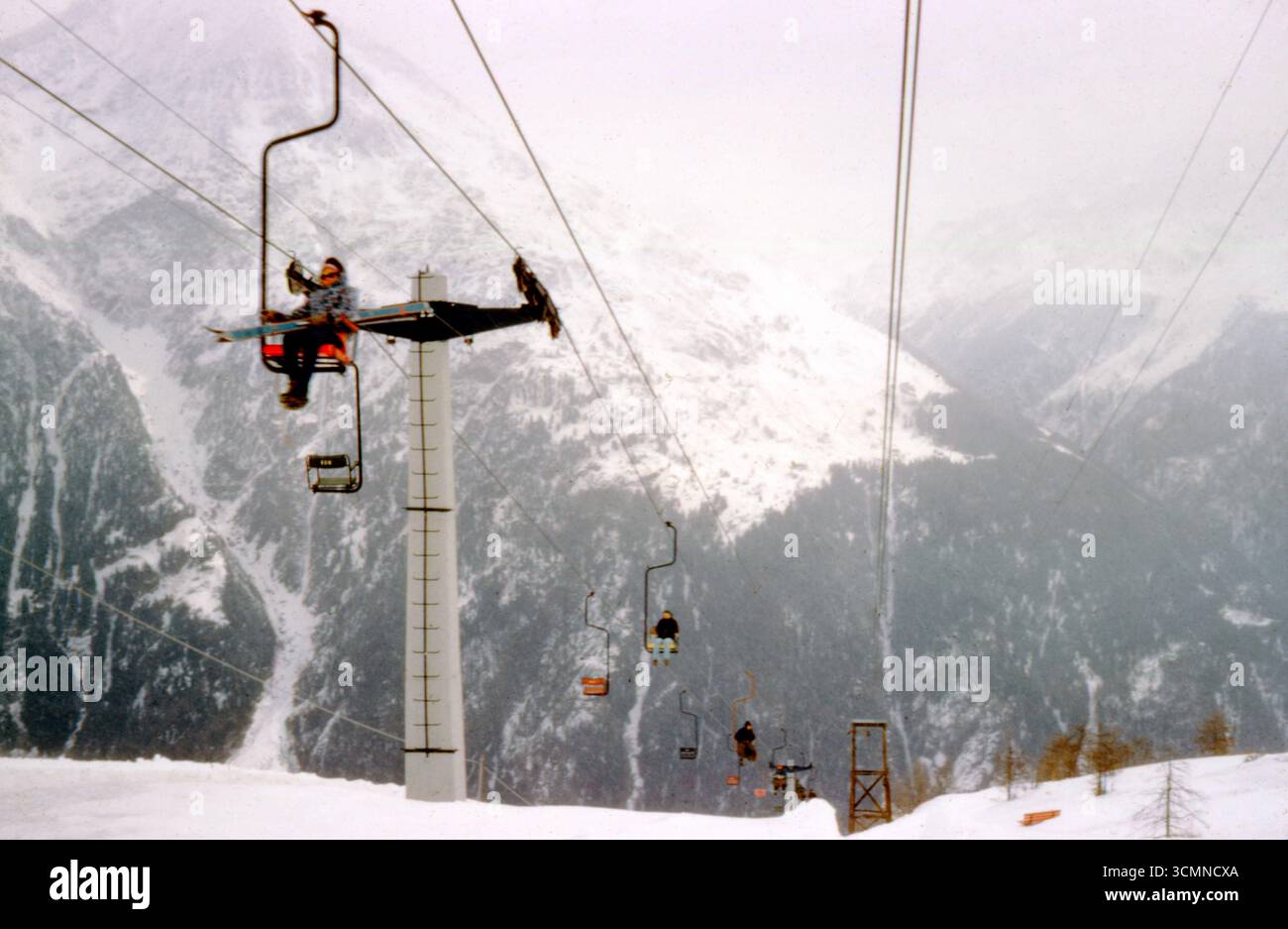 Gli sciatori in seggiovia salgono le piste innevate della stazione sciistica di Sölden, Tirolo, Austria, nelle Alpi di Ötztal, inverno 1963. Foto Stock
