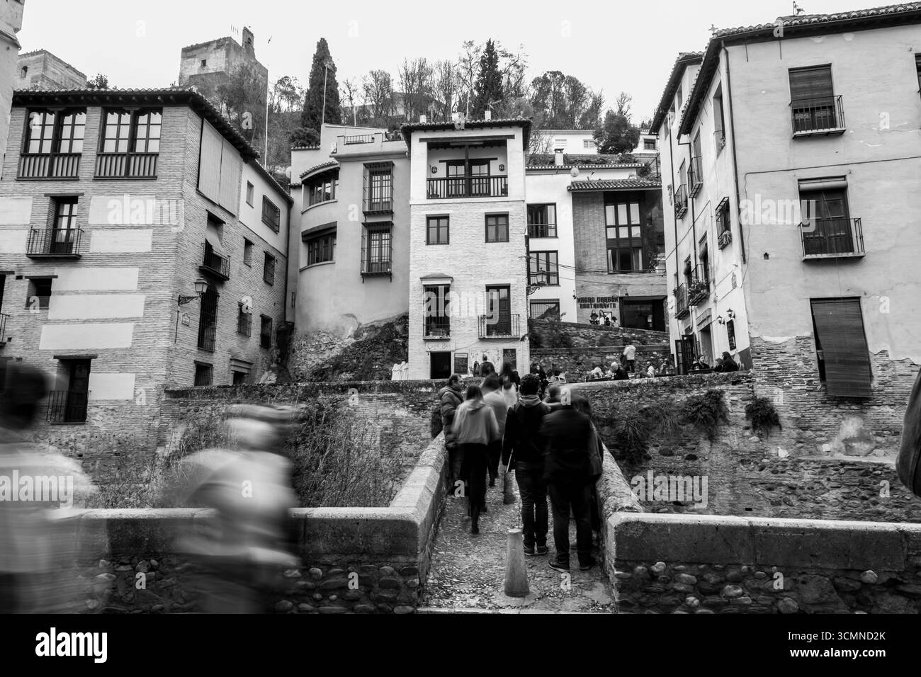 Granada, Spagna-26 febbraio 2022: Gruppi di visitatori che camminano lungo le strade storiche intorno al fiume Darro, Granada, Spagna. Foto Stock