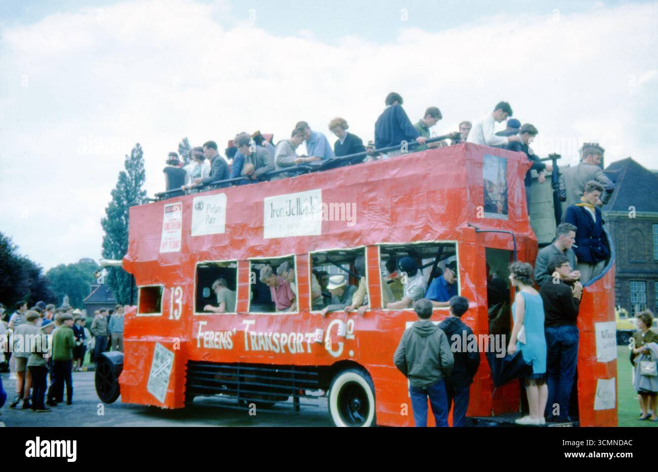 University of Hull RAG Week float, 1963 - studenti su un autobus rosso a due piani fatto a mano che promuove Ferens Transport Co. Per una parata di beneficenza. Foto Stock