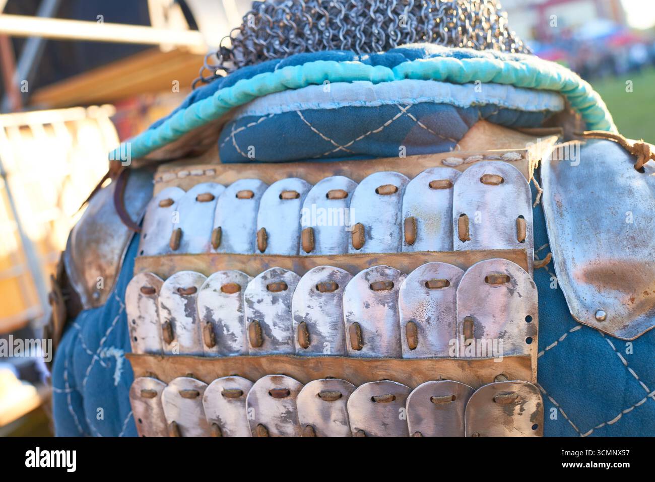 Vista dall'alto di un uomo che indossa armature storiche con piatti di metallo e catene, che partecipa a un evento di rievocazione all'aperto o a un festival medievale Foto Stock