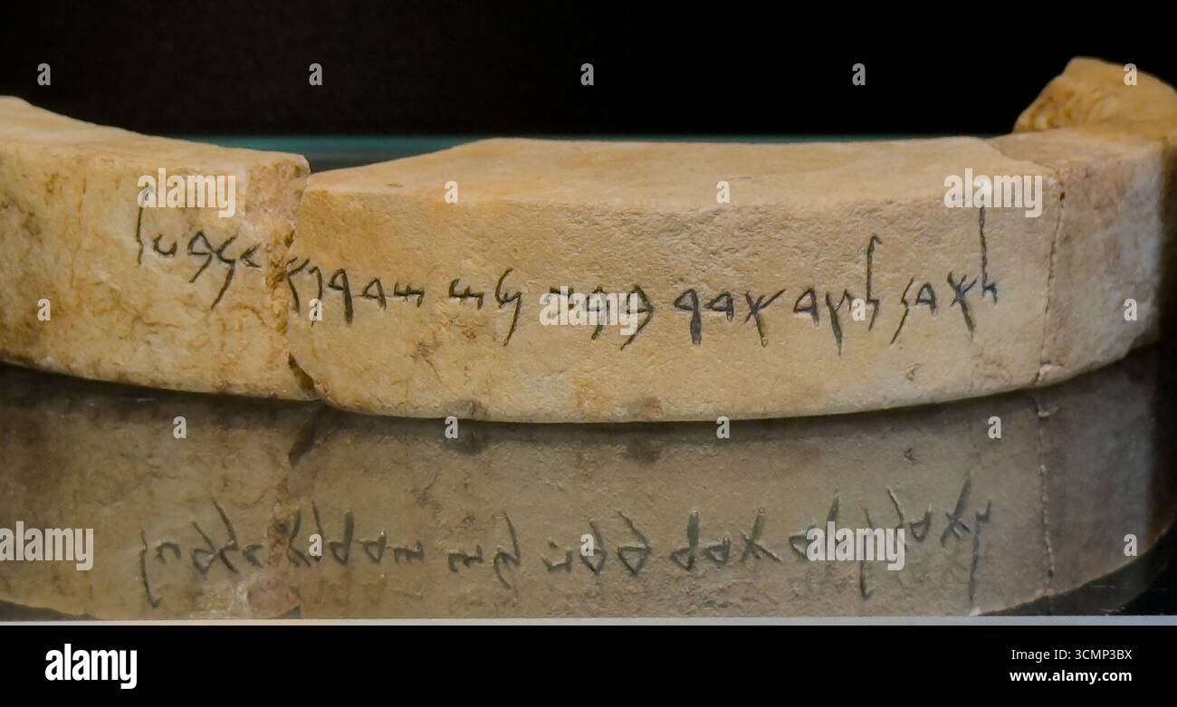 Manufatto archeologico che mostra un antico frammento di pietra con iscrizione fenicia rinvenuto in Sardegna Foto Stock