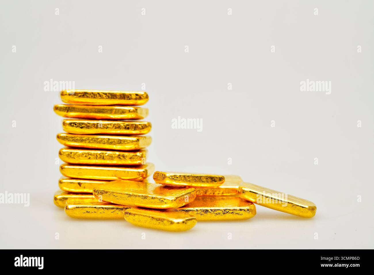 Molte barre dorate lucide su sfondo bianco Foto Stock