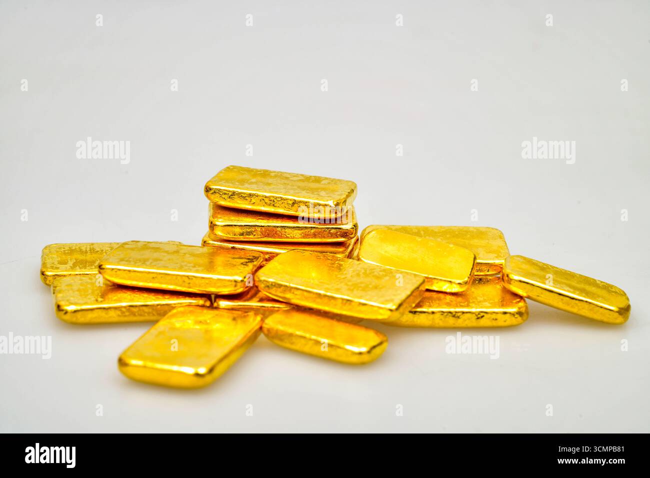 Molte barre dorate lucide su sfondo bianco Foto Stock