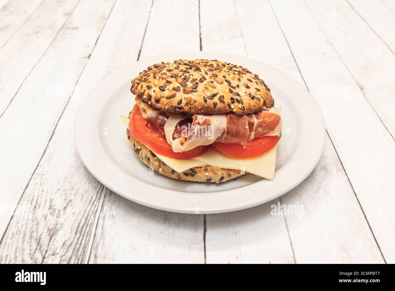 Panino di prosciutto iberico: Maiale di prima qualità nutrito con ghiande, pomodori tritati e olio extra vergine d'oliva su pane cristallo Foto Stock