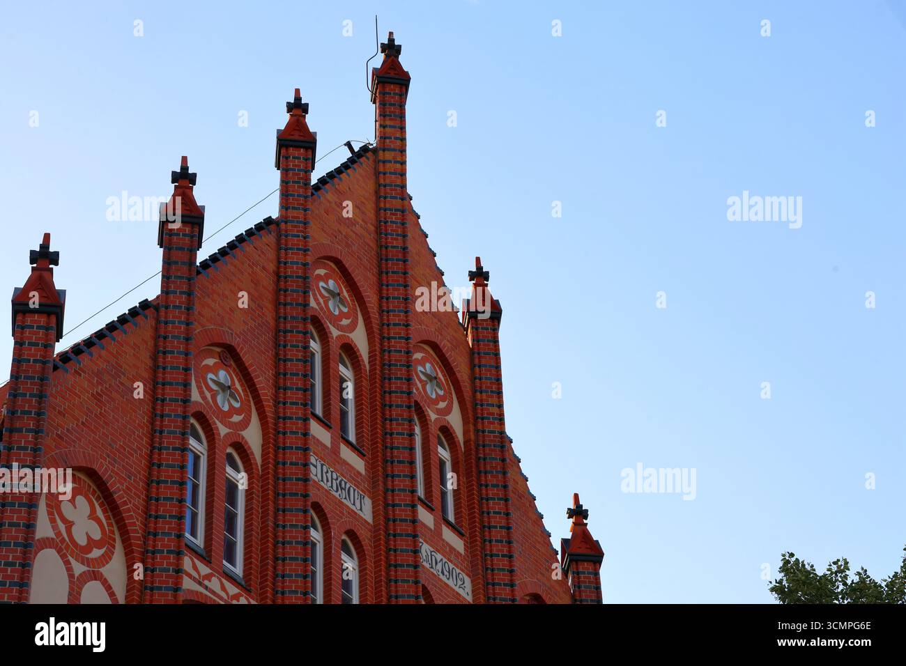 Architettura gotica in mattoni rossi con guglie ed elementi decorativi Foto Stock