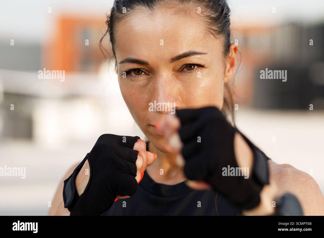 Primo piano ritratto dettagliato di una giovane sportiva in posa in battaglia e che guarda la fotocamera Foto Stock