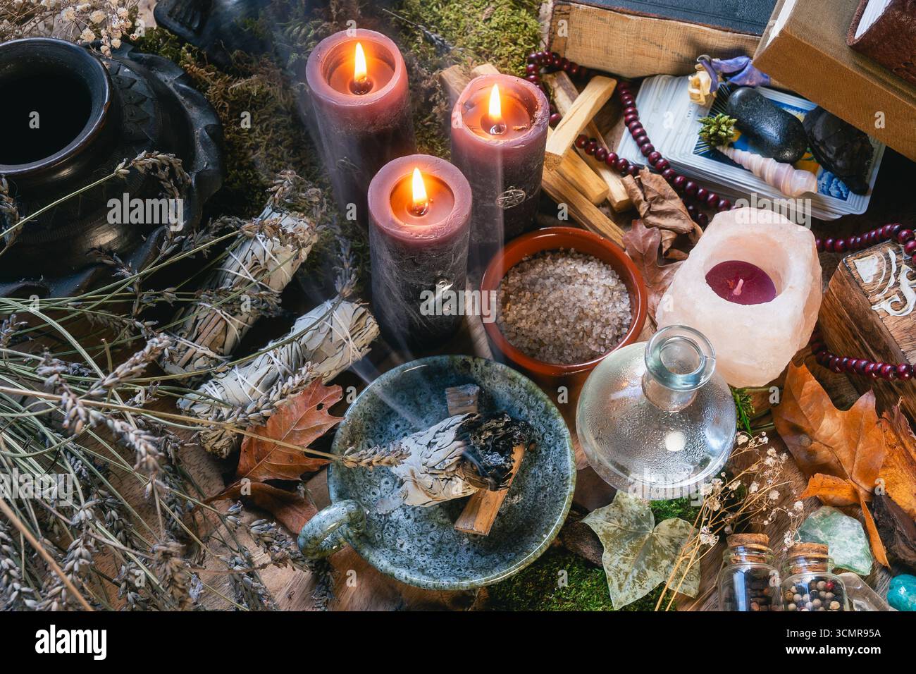Allestimento dell'altare Wiccan incantato con candele bruciate, cristalli, erbe e strumenti rituali per la guarigione spirituale e la pulizia energetica. Foto Stock