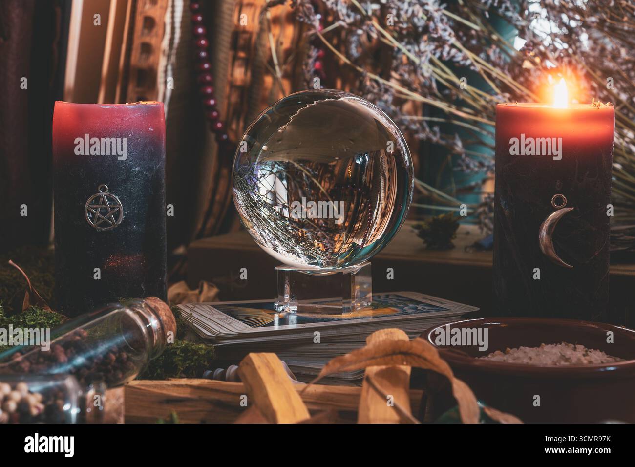 Scena spirituale dell'altare Wiccan con una palla di cristallo, carte di tarocchi, candele, erbe e strumenti magici utilizzati per la divinazione e il lavoro rituale. Foto Stock