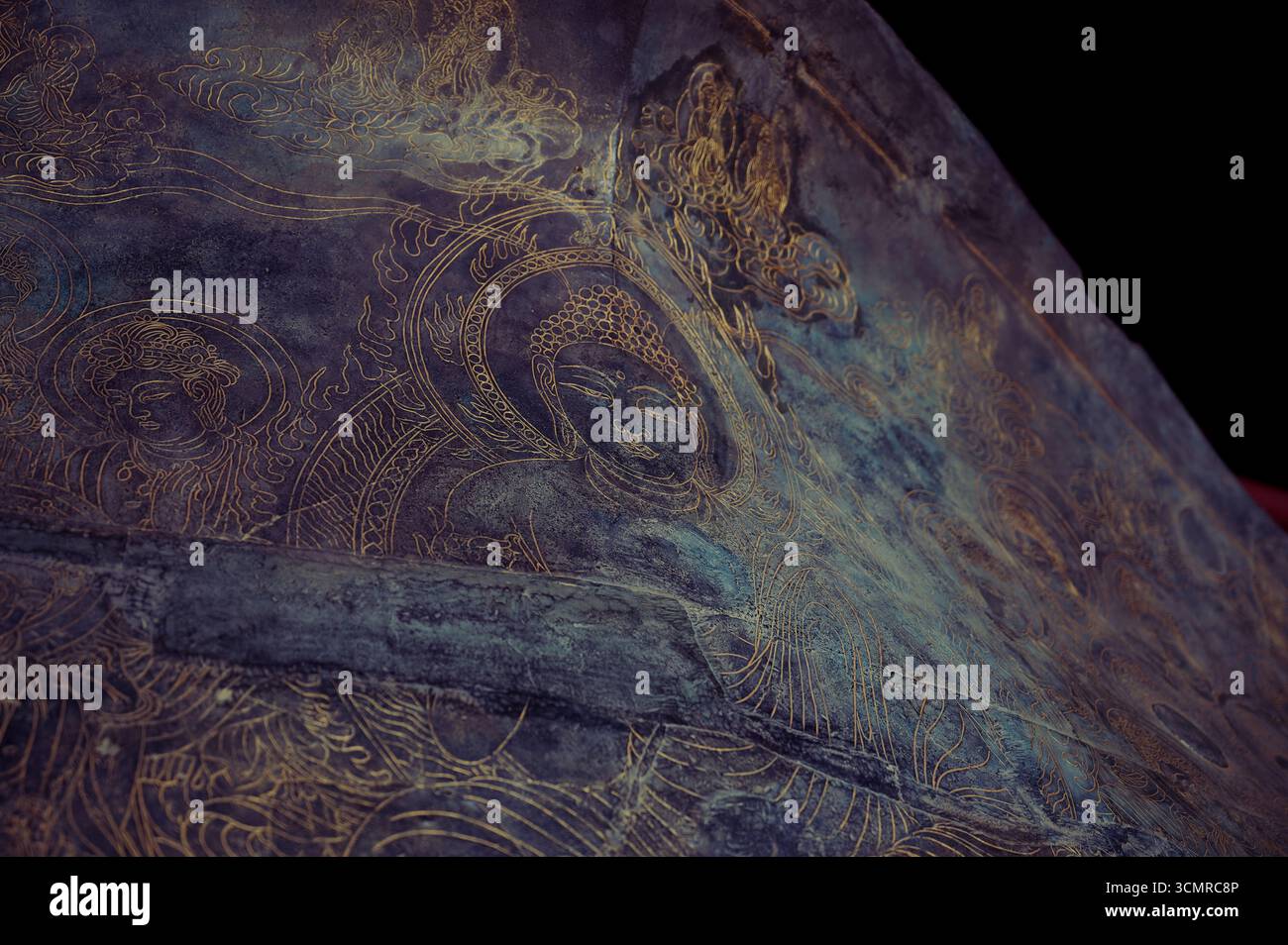 Delicata arte in linea dorata di figure di buddha su una superficie scura all'interno del tempio Todai-ji a Nara Foto Stock