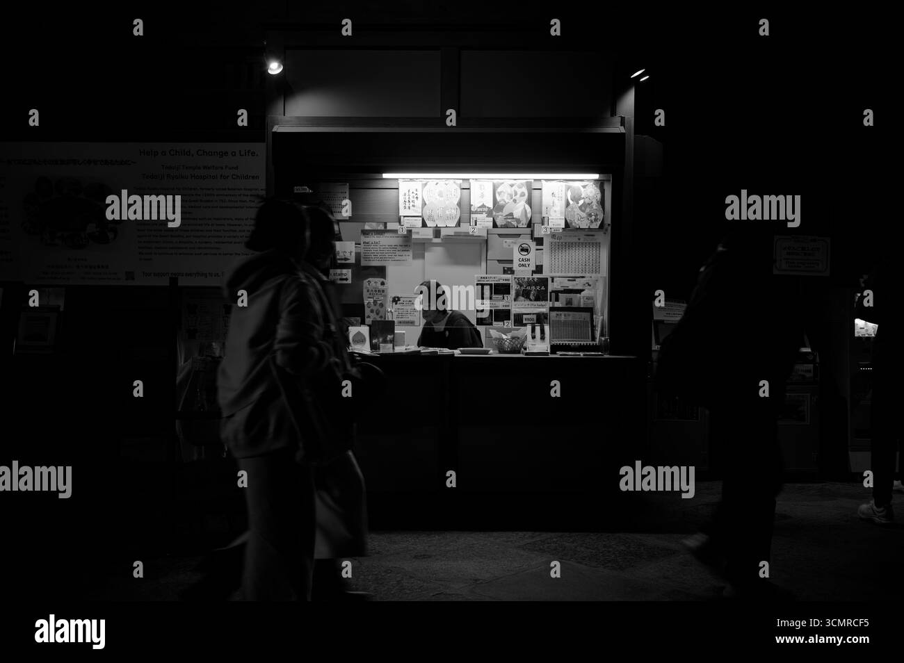 Bancone souvenir poco illuminato all'interno del tempio Todai-ji di Nara in bianco e nero Foto Stock