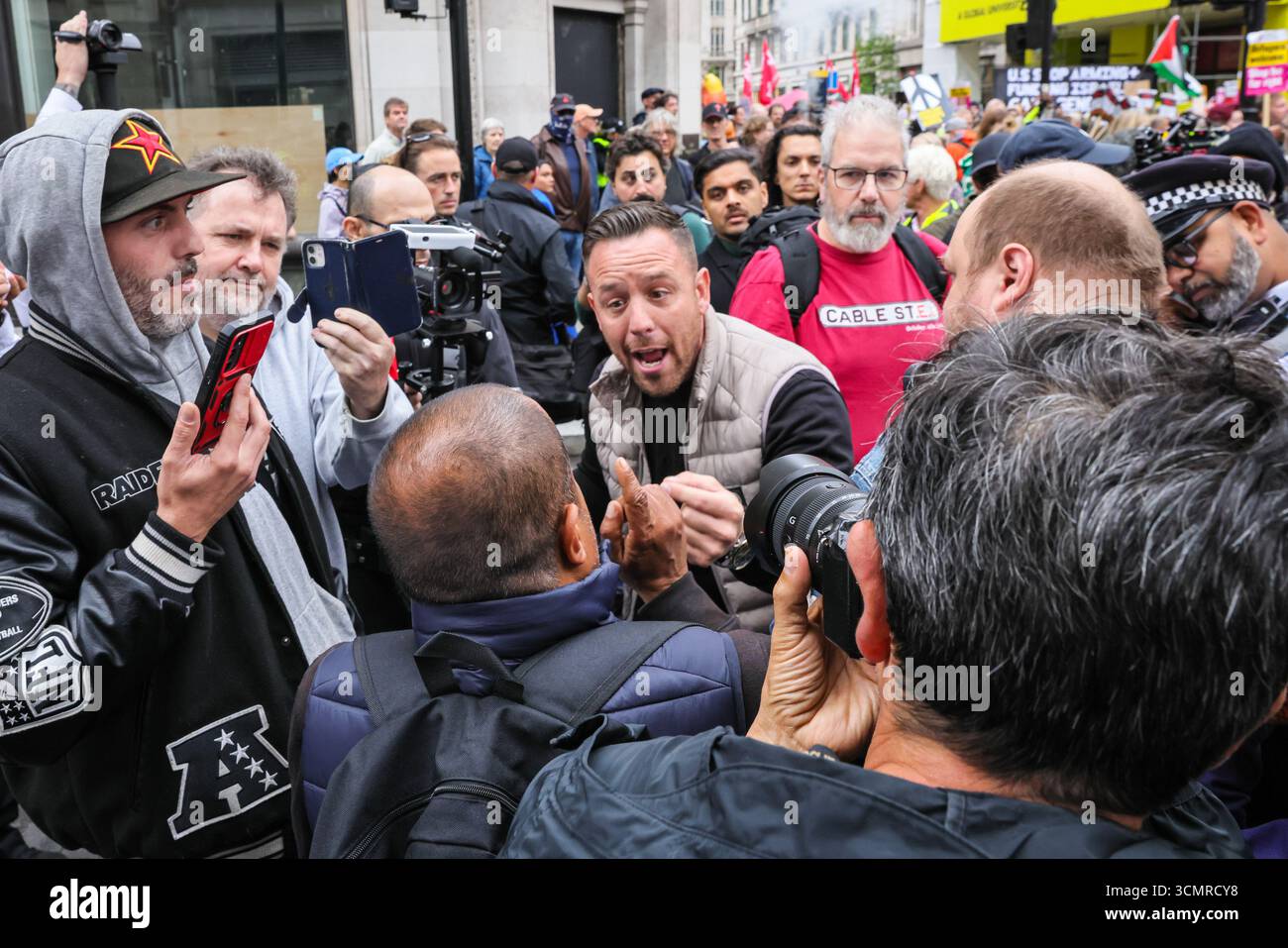 Londra, Regno Unito. 17 settembre 2025. YouTuber, attivista di destra e sostenitore di Trump Danny Tommo tenta di interrompere la protesta più volte con i suoi messaggi ed è immediatamente circondato da fotografi. Folle di manifestanti si radunano e marciano contro la visita di stato del presidente degli Stati Uniti Donald Trump nel Regno Unito. Il "Trump Not Welcome" intitolato march from Portland Square to Parliament Square è una delle tante proteste a Londra e Windsor. Crediti: Imageplotter/Alamy Live News Foto Stock