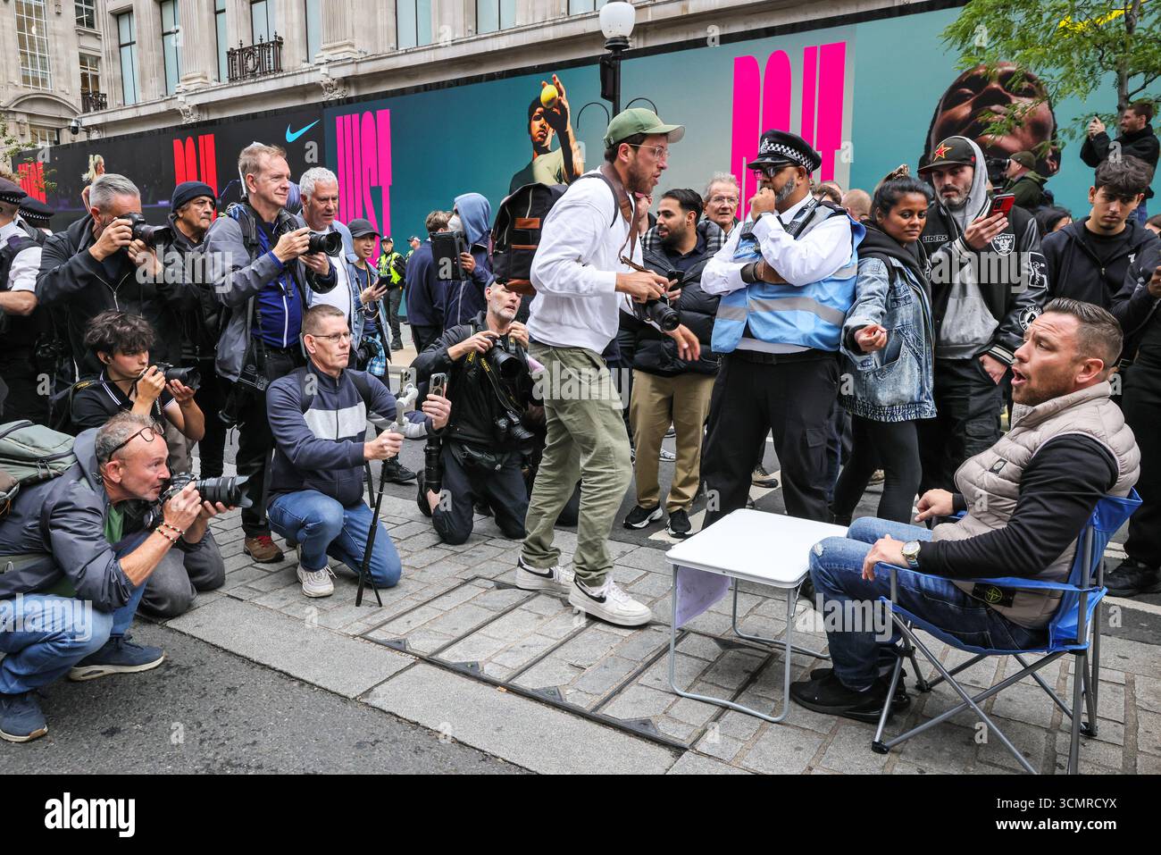 Londra, Regno Unito. 17 settembre 2025. YouTuber, attivista di destra e sostenitore di Trump Danny Tommo tenta di interrompere la protesta più volte con i suoi messaggi ed è immediatamente circondato da fotografi. Folle di manifestanti si radunano e marciano contro la visita di stato del presidente degli Stati Uniti Donald Trump nel Regno Unito. Il "Trump Not Welcome" intitolato march from Portland Square to Parliament Square è una delle tante proteste a Londra e Windsor. Crediti: Imageplotter/Alamy Live News Foto Stock