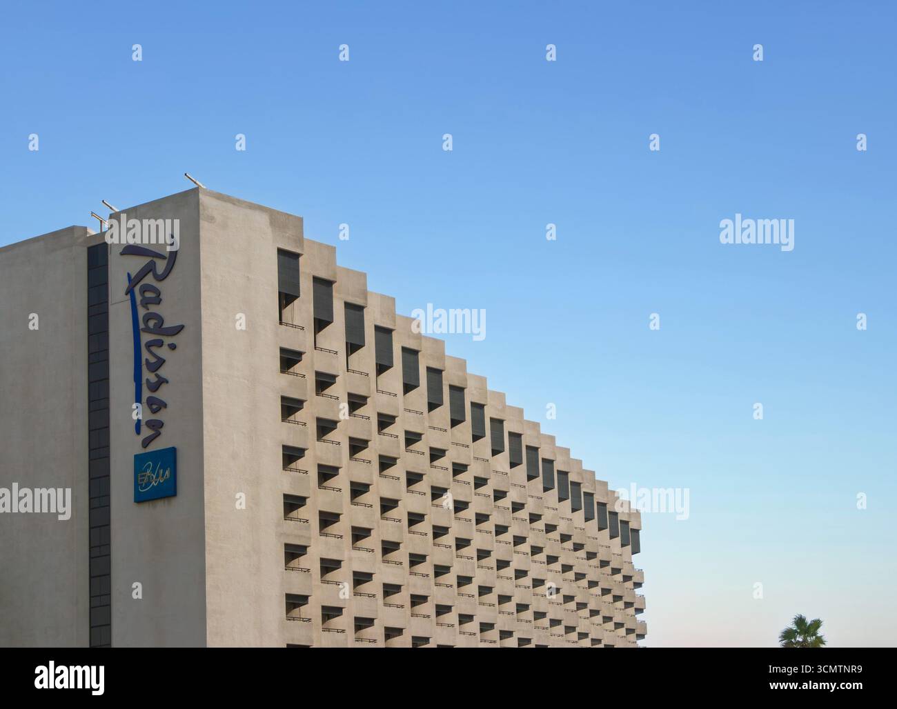 Esterno del radisson blu hotel dubai, facciata architettonica unica sotto un cielo azzurro limpido con numerosi balconi Deira creek UAE Foto Stock