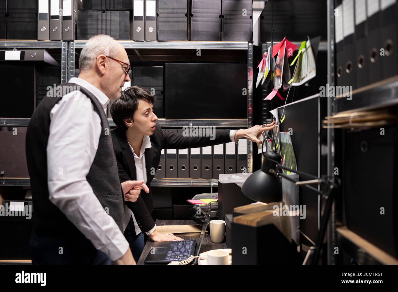 Squadra di investigatori privati che collega i registri con le foto e le dichiarazioni dei testimoni su una bacheca misteriosa, raccoglie informazioni e garantisce l'autenticità in un'indagine di polizia penale. Foto Stock