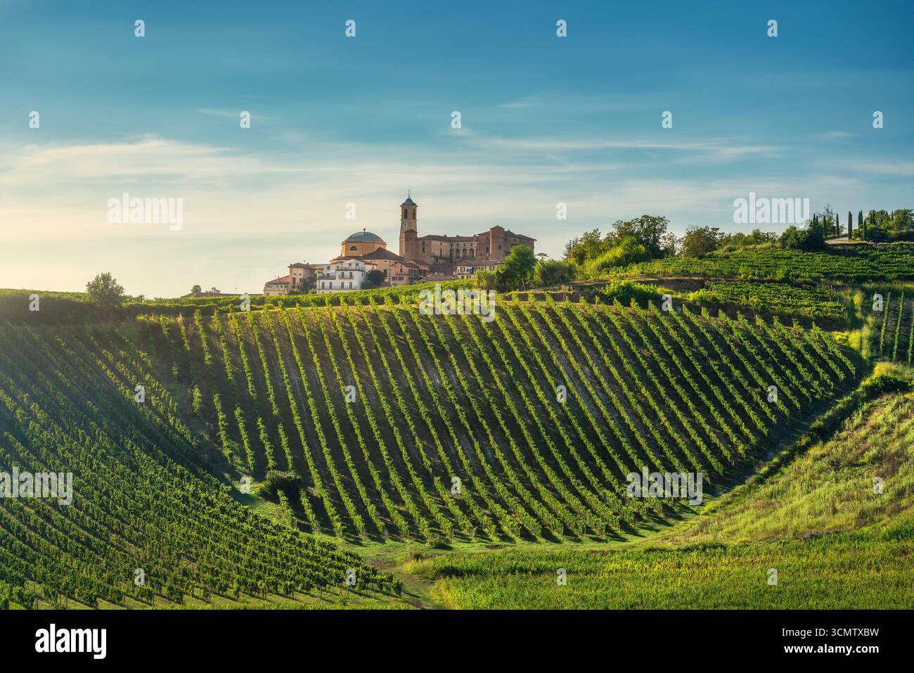 Vista panoramica del borgo storico di Montegrosso d'Asti circondato da vigneti terrazzati nella regione vinicola piemontese. Colline ondulate e vin geometrico Foto Stock