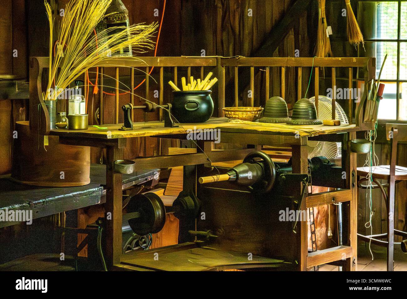 Monroe, New York - Stati Uniti - 6 settembre 2025 storico laboratorio interno di scopa con attrezzi, fasci di paglia e attrezzature in legno in mostra. Foto Stock