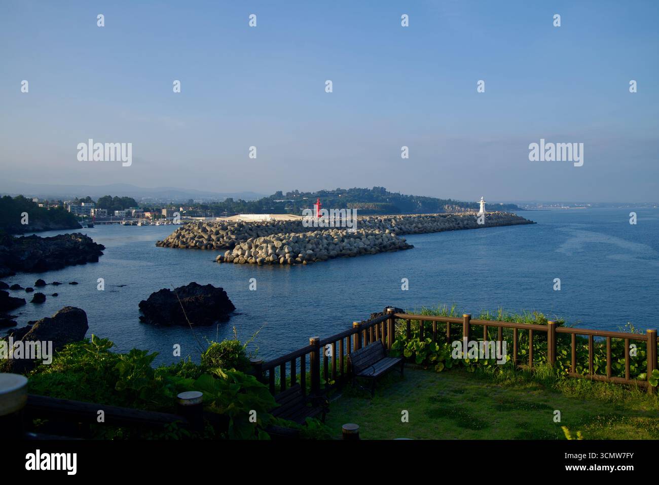 Dal parco costiero sopra il porto di Hahyo, le torri faro rosse e bianche si ergono su getti opposti oltre il dolosse, riparando il porto mentre il Foto Stock