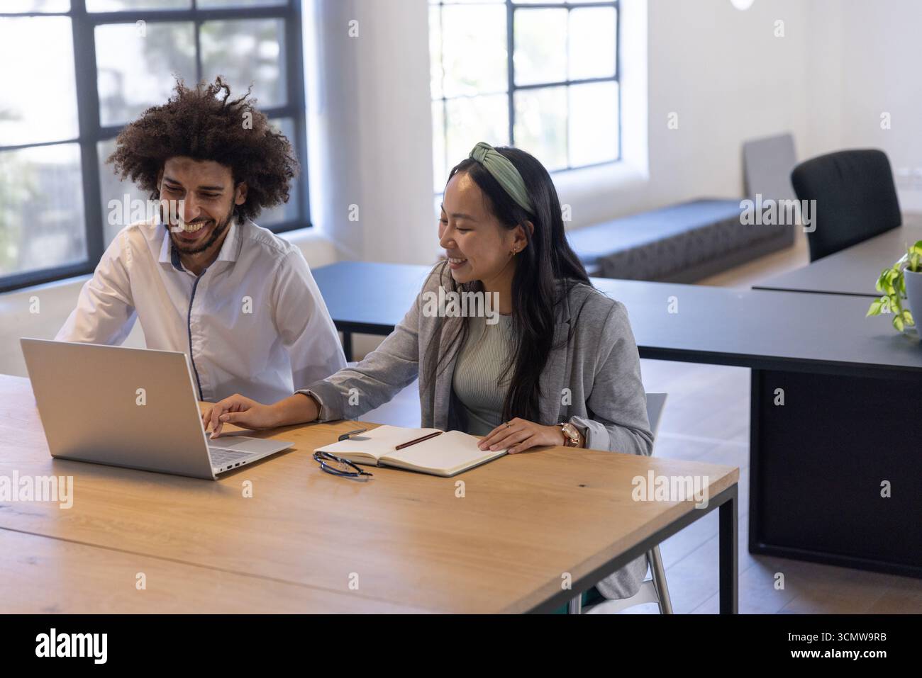 Colleghi diversi che lavorano alla scrivania dell'ufficio con computer portatile, notebook, penna, occhiali, vasetti Foto Stock
