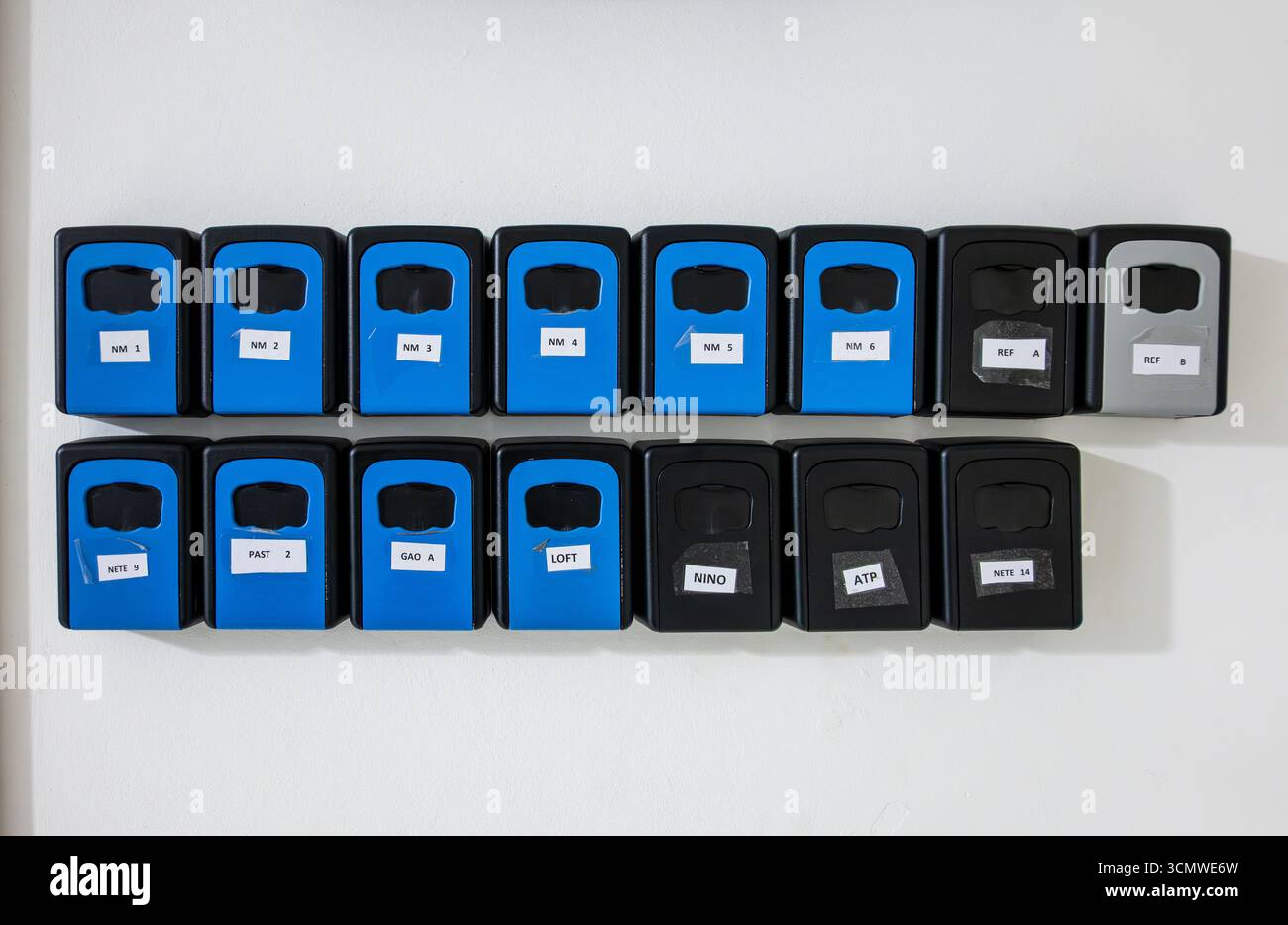 Fila di cassette per chiavi cassette per chiavi cassette per chiavi cassette di sicurezza per chiavi per appartamenti Airbnb appartamenti affitti vacanze nel corridoio di un edificio Foto Stock