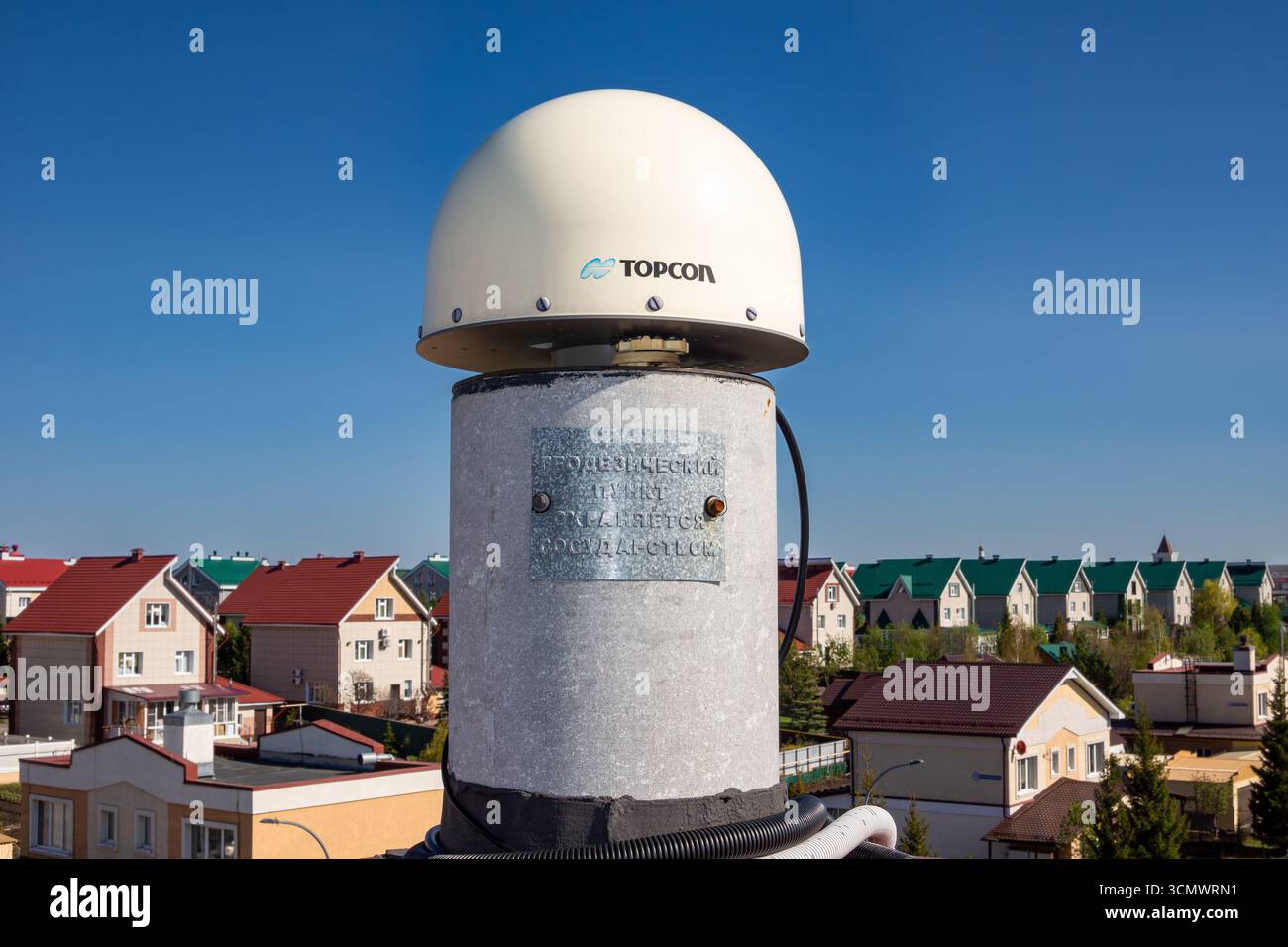Russia, Kemerovo - 17 maggio 2024. Ricevitore satellitare geodetico fisso con antenna a cupola bianca montata su una colonna metallica, etichettata Geodetic Point Protecte Foto Stock