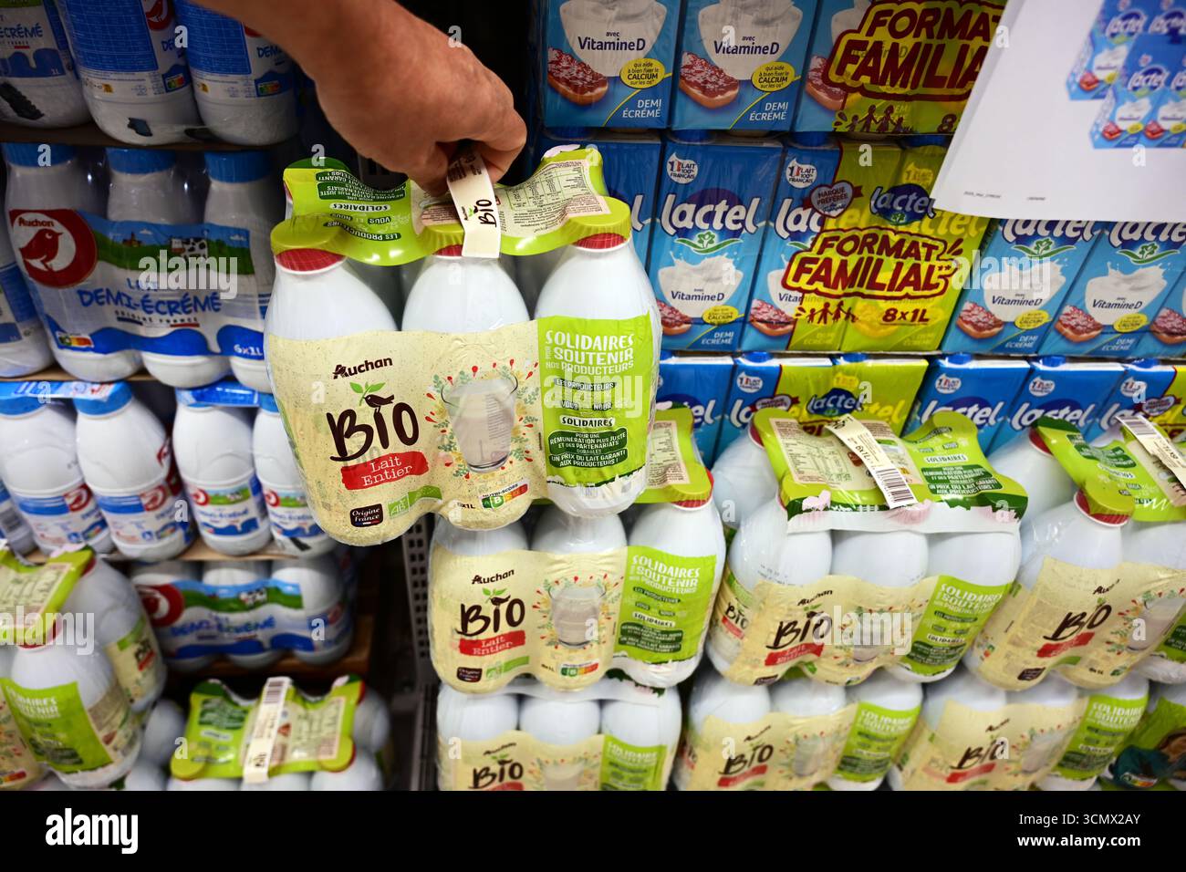 Il cliente preleva il latte Bio da sei confezioni al supermercato Foto Stock