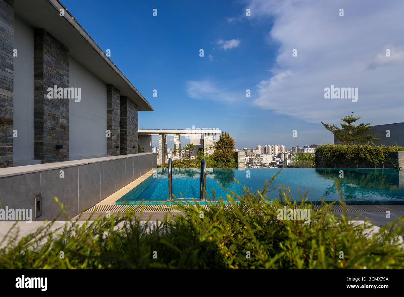 Esclusiva piscina sul tetto con vista mozzafiato sulla città, che offre un soggiorno di lusso e un tranquillo spazio all'aperto. Foto Stock