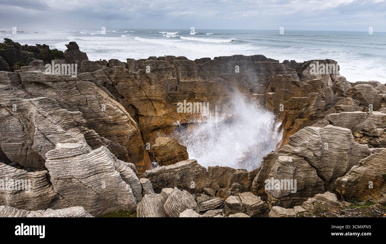 Acqua di mare che attraversa Blowhole in Sculpected Rock a Pancake Rocks, Punakaiki, nuova Zelanda Foto Stock